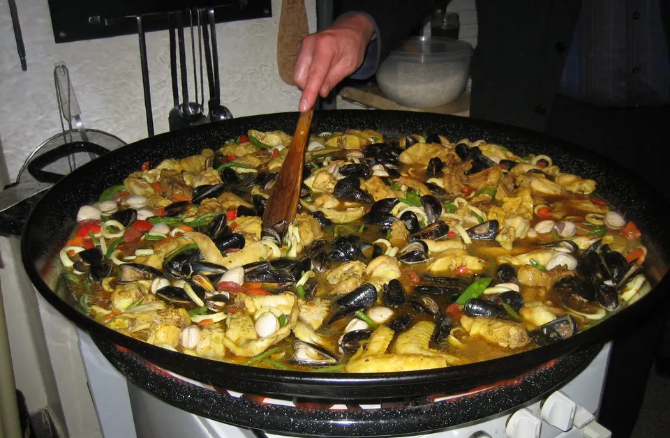 Paella cocinándose en una paellera grande