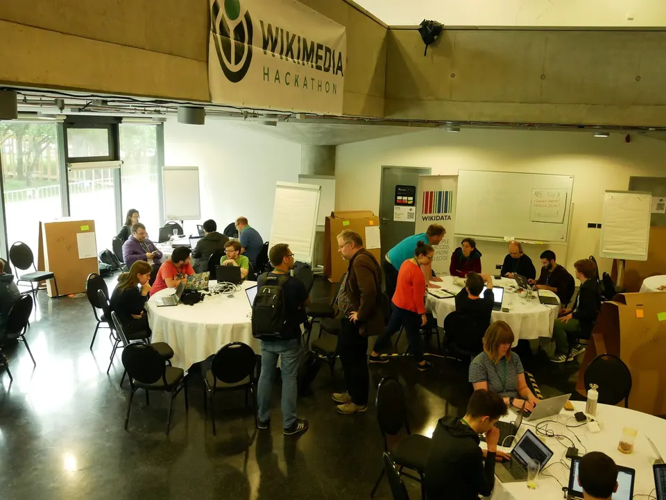 Equipos trabajando con portátiles en un hackathon