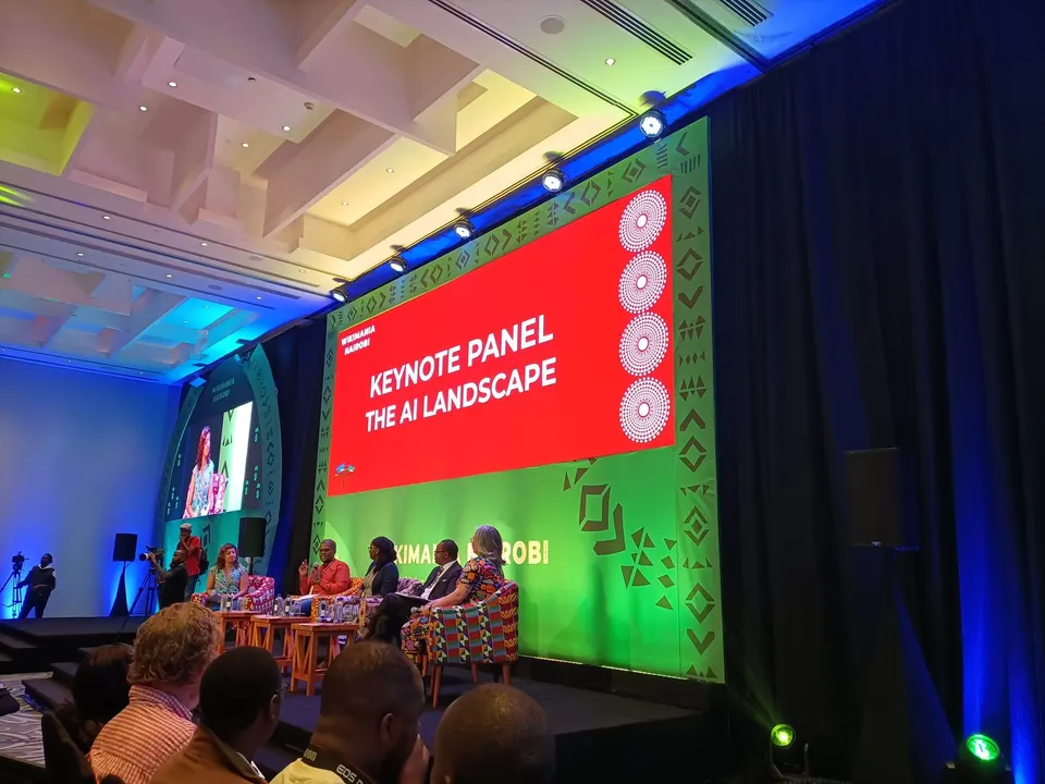 Panel de ponentes en un escenario ante el público